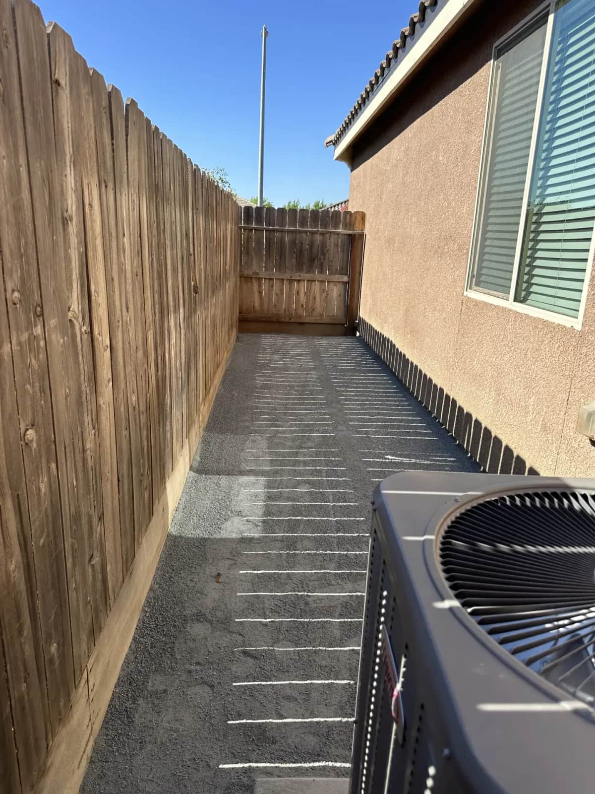 DG side yard with wood fence and AC unit