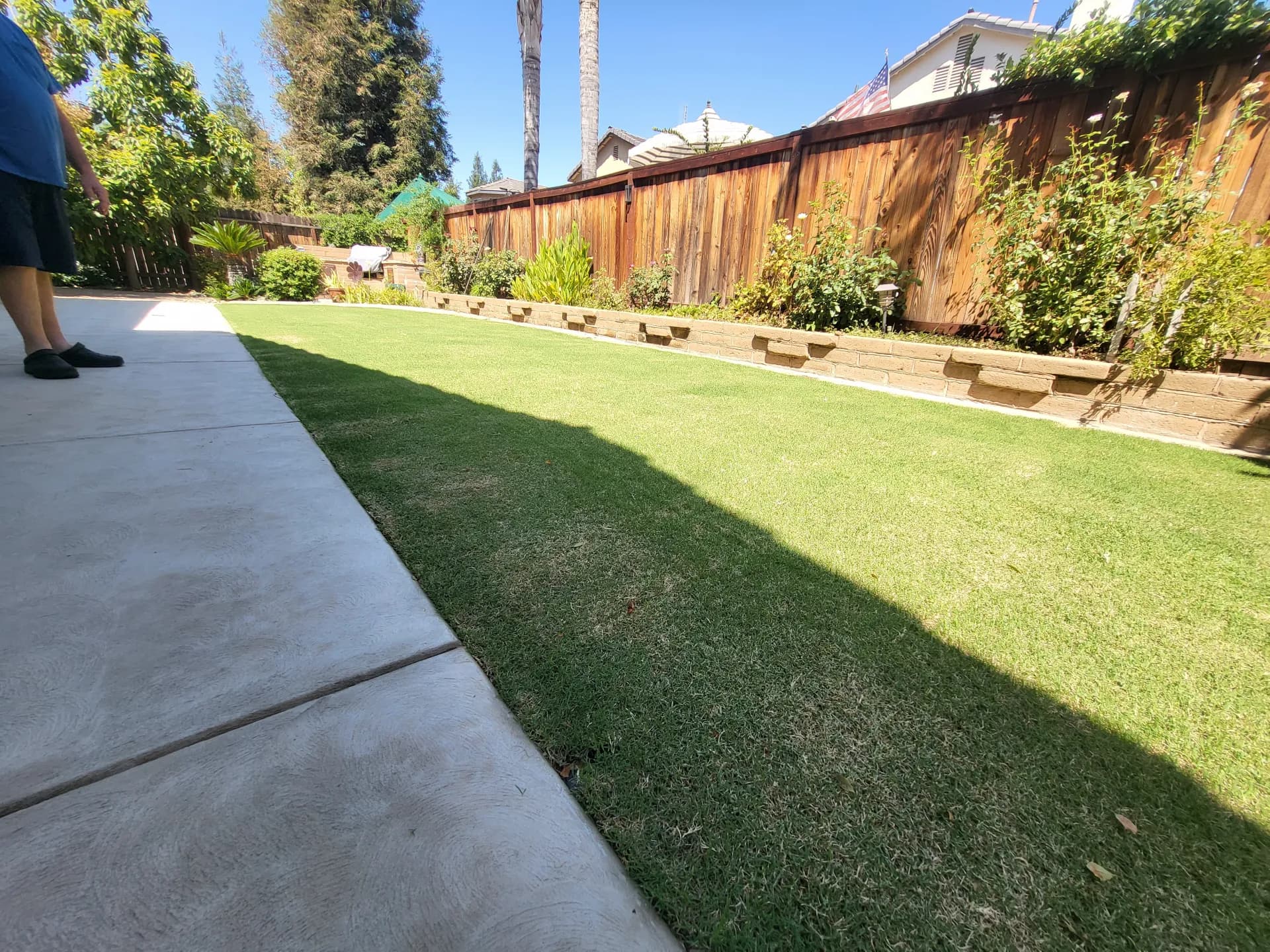 Backyard stacked block retaining wall with tropical plants