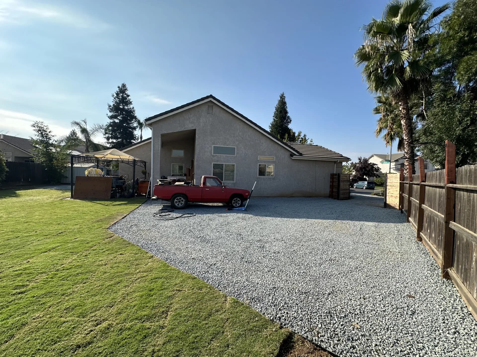 Backyard gravel parking pad with truck
