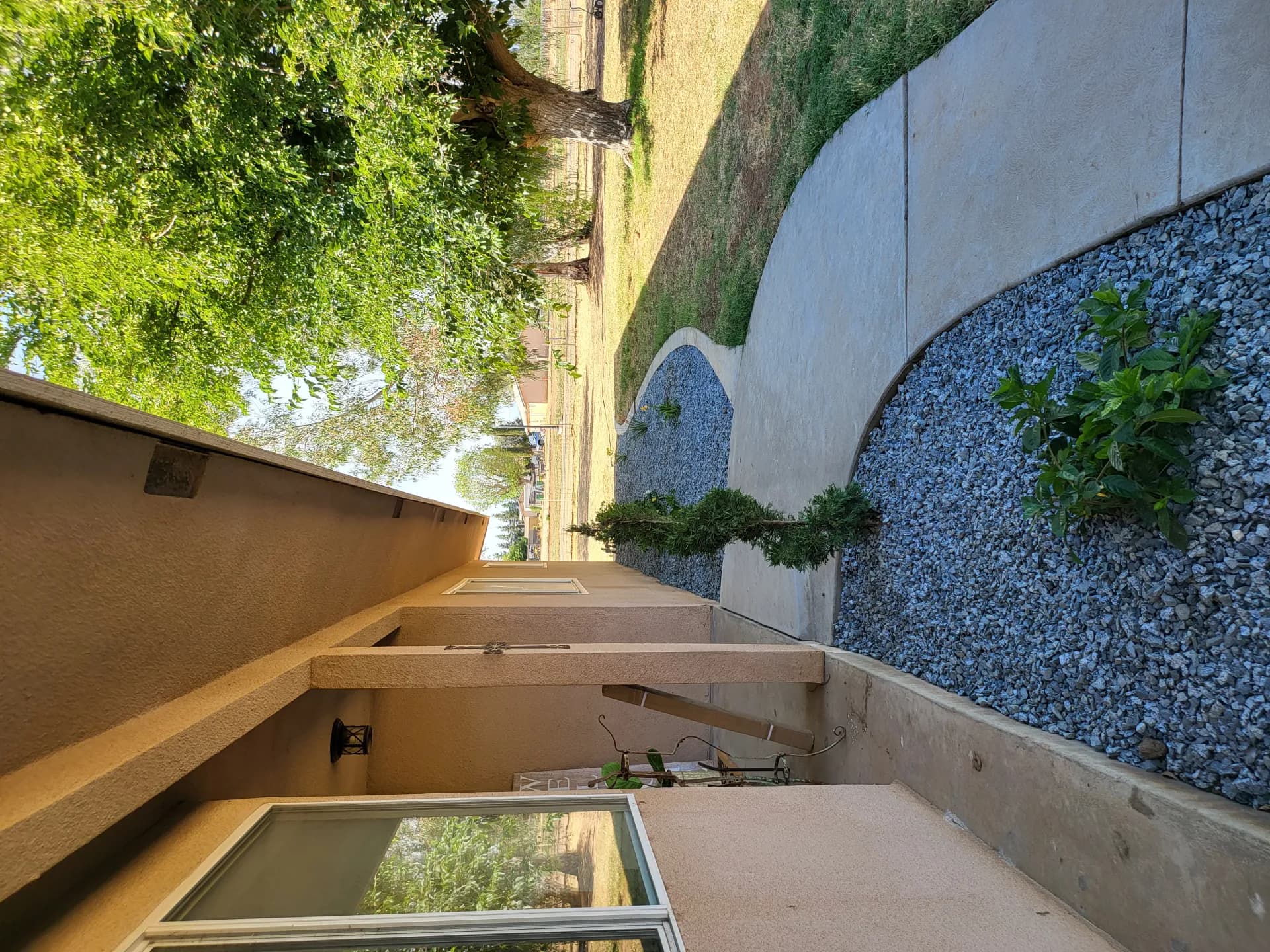 Side yard gravel walkway with shrubs