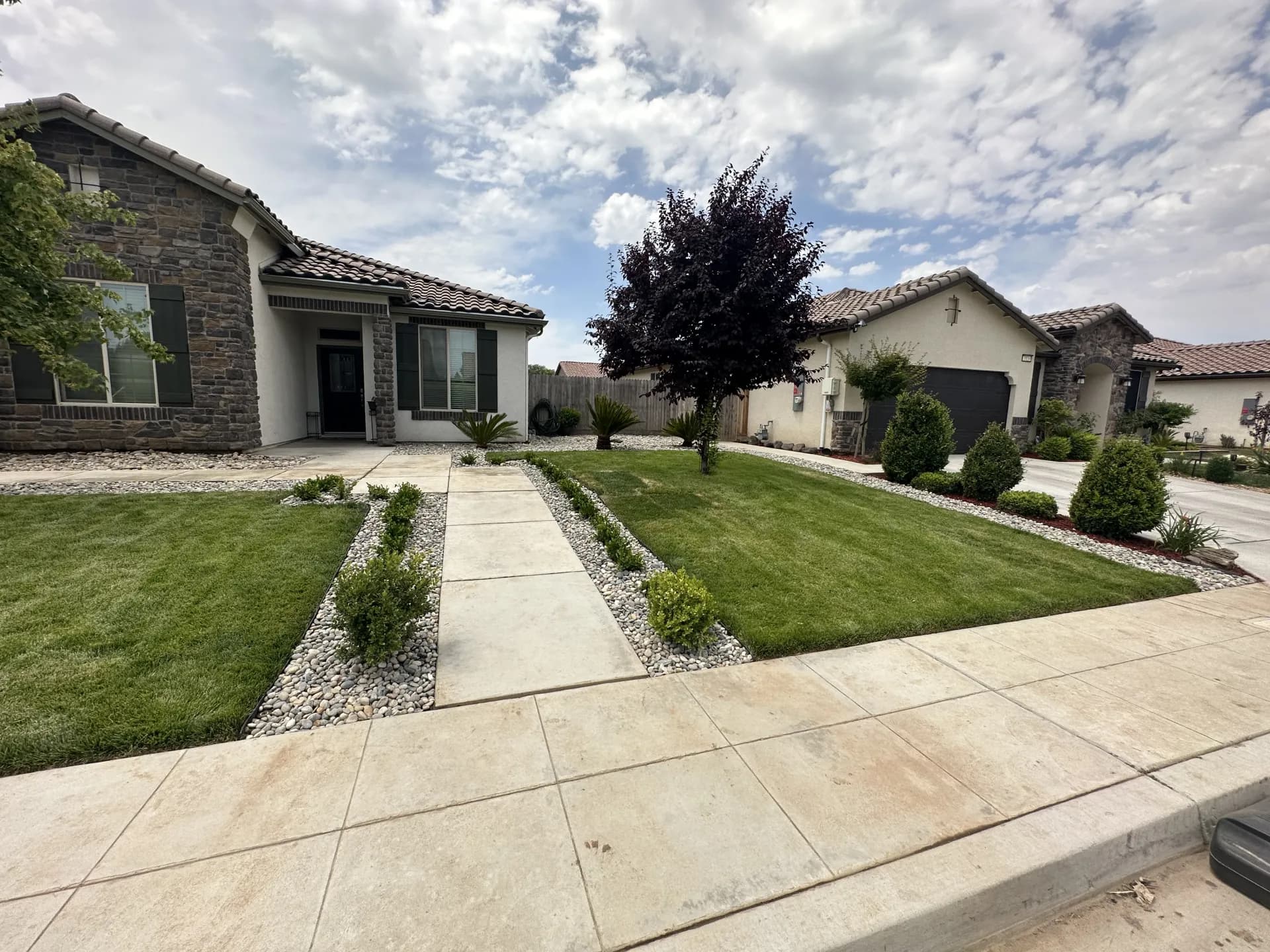 Front yard sod at stone home with walkway